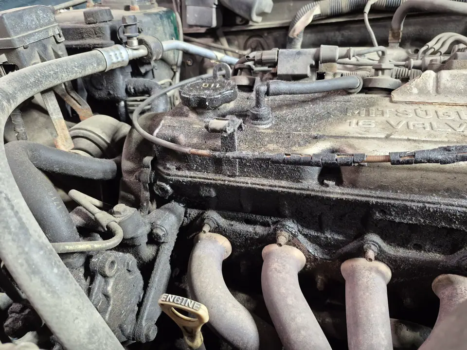 Клапанная крышка Mitsubishi 16 VALVE и выпускной коллектор до чистки: масляные потёки, пыль, черный нагар